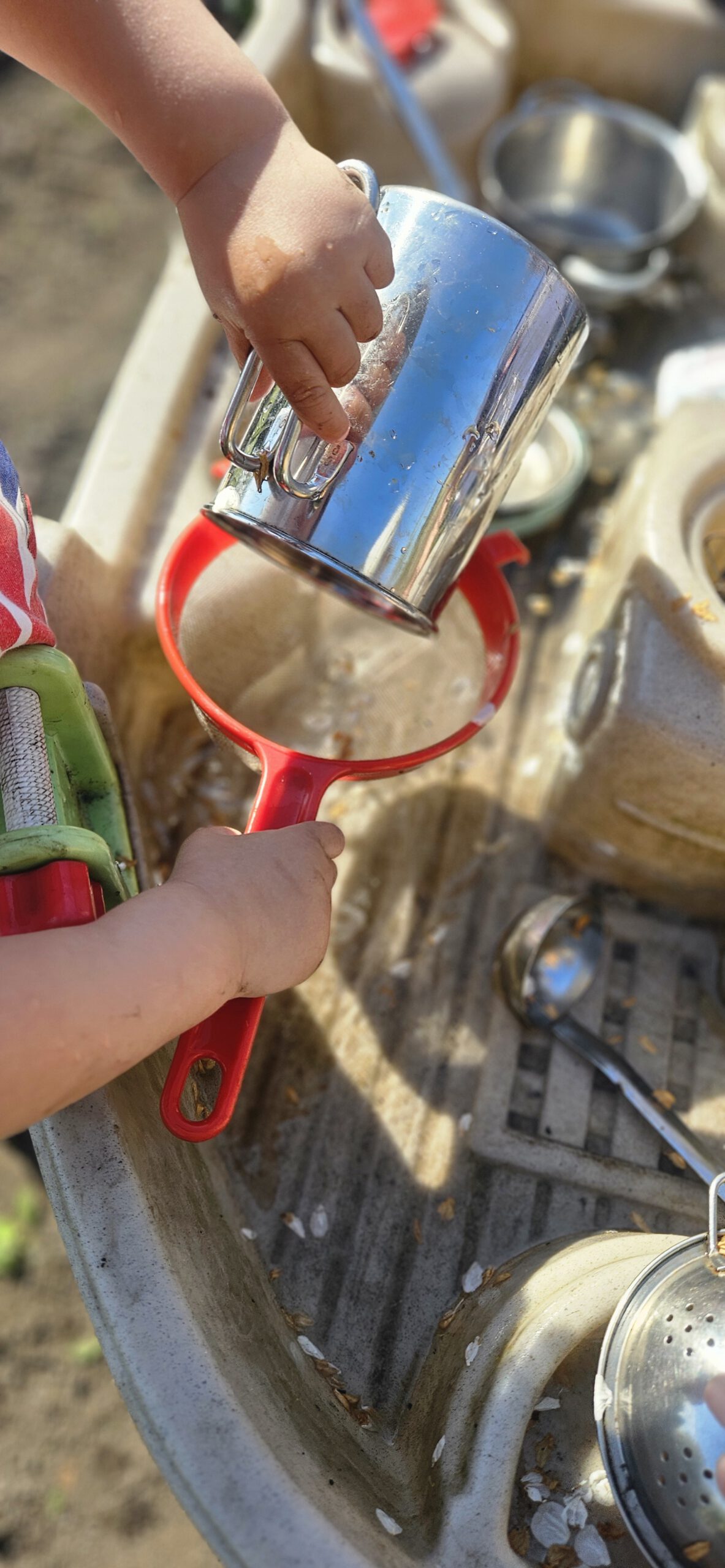 Kinder spielen an der Matschküche