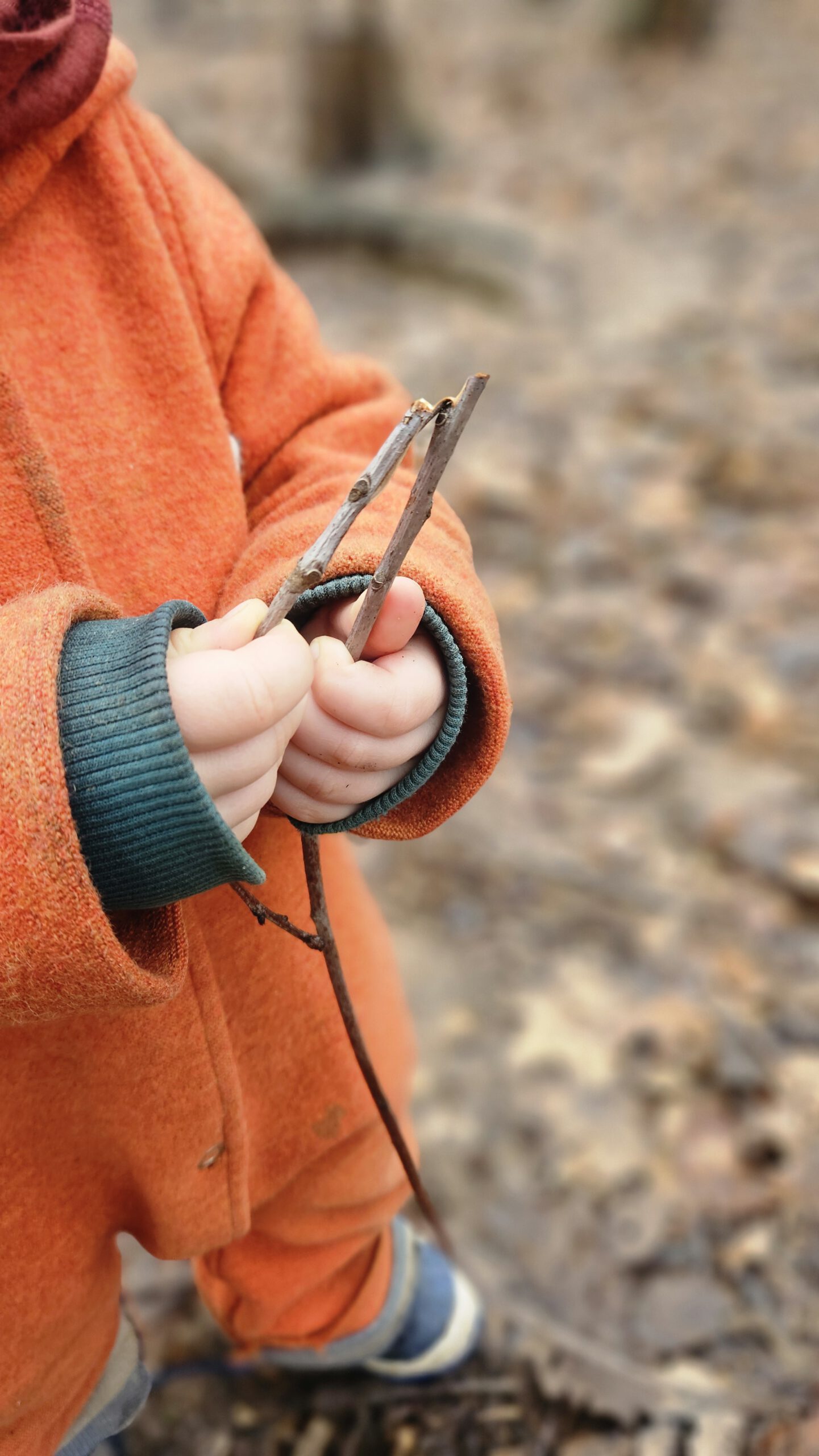 Kind mit Stöcken in der Hand