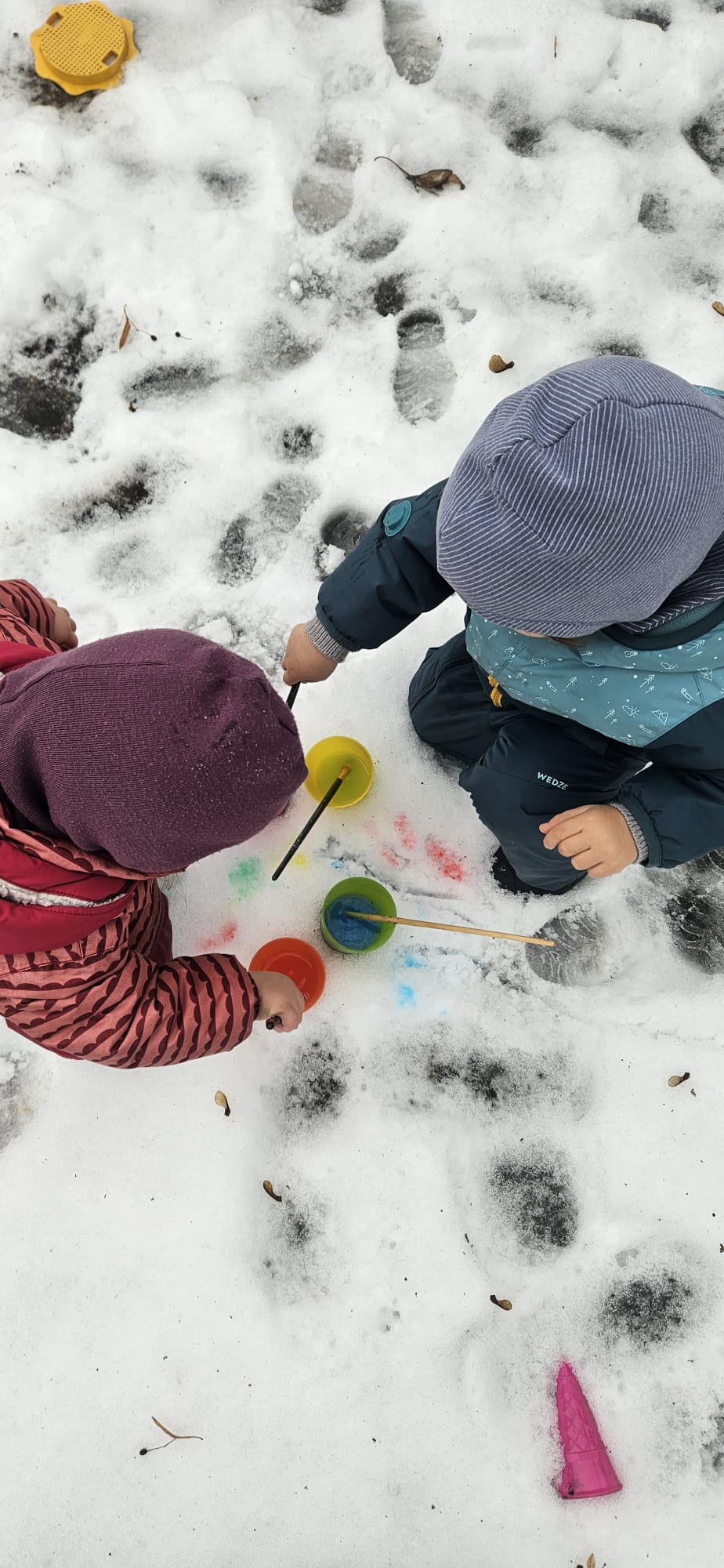 Kinder malen mit Farben im Schnee