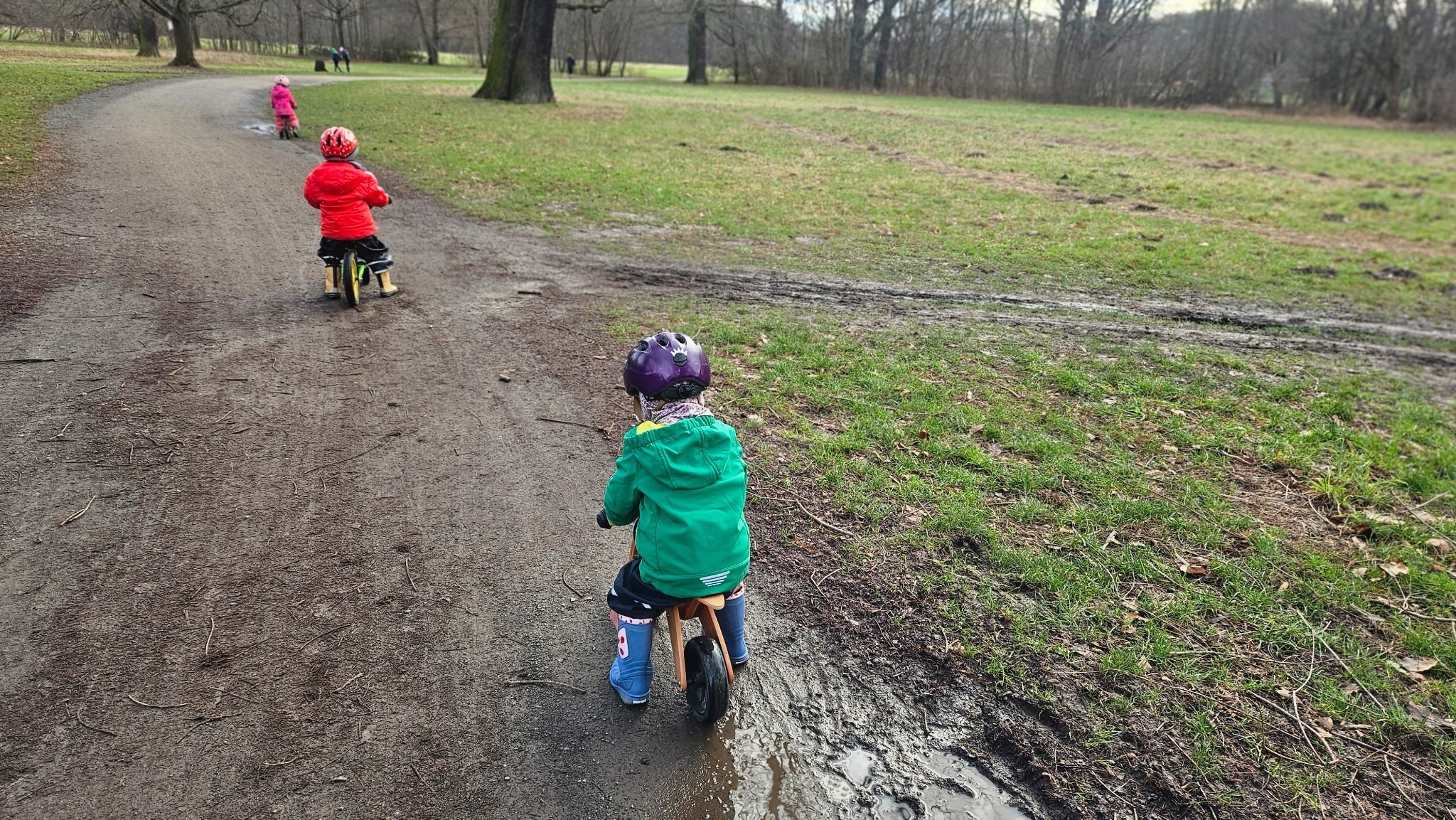 Kinder fahren Laufrad im Park